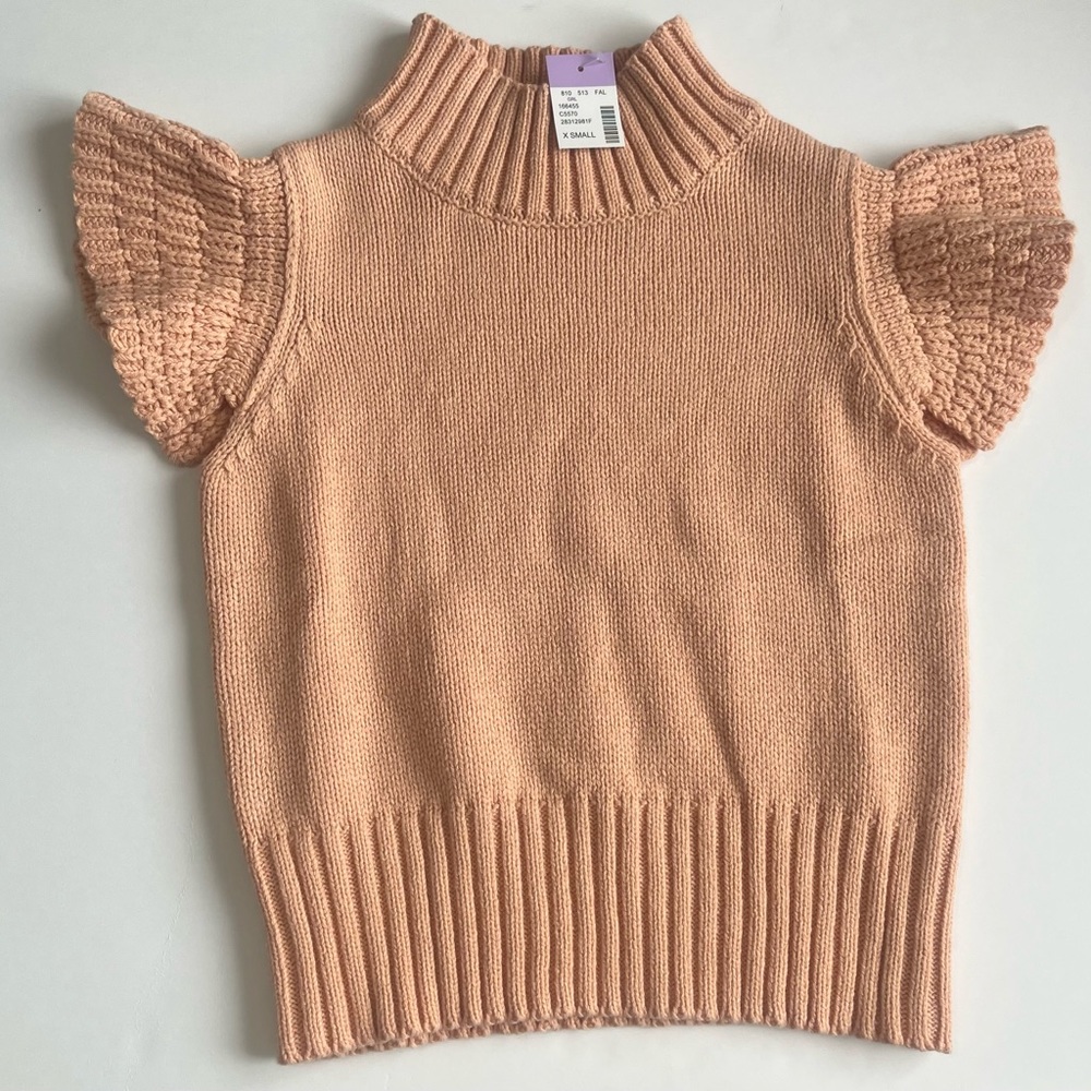 Peach knit crop blouse with flair sleeves.